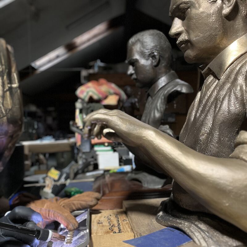 Life-size portrait busts in progress on the studio bench