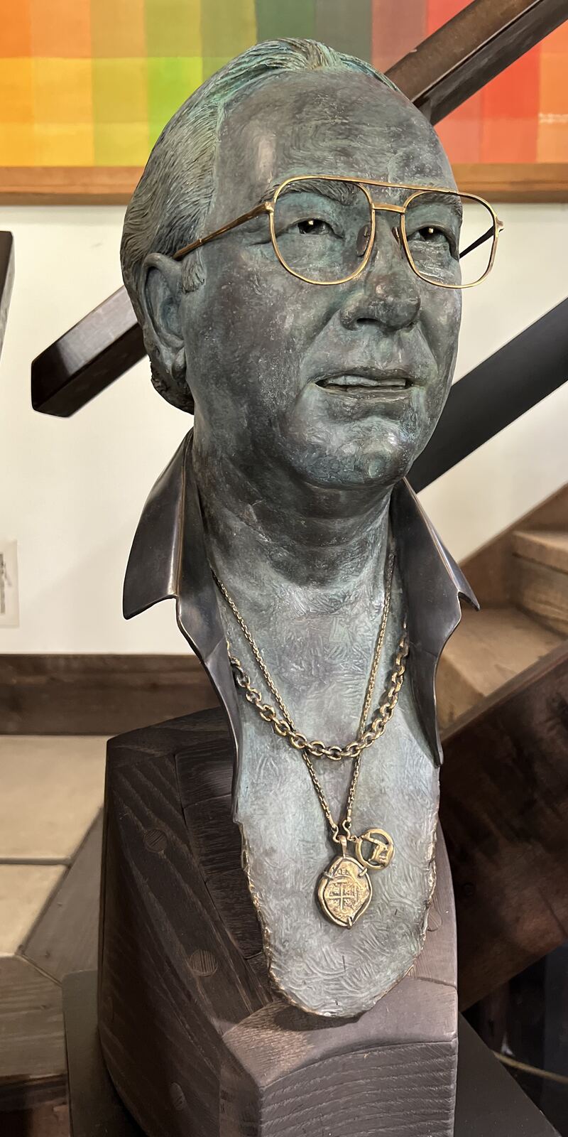 Portrait bust of a man in glasses wearing a pendant necklace