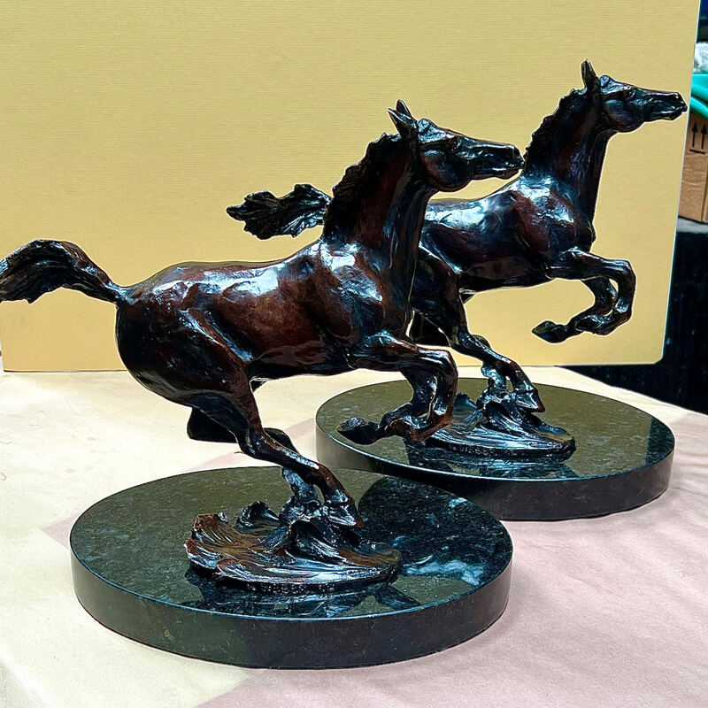 Pair of bronze horses rearing on dark round bases